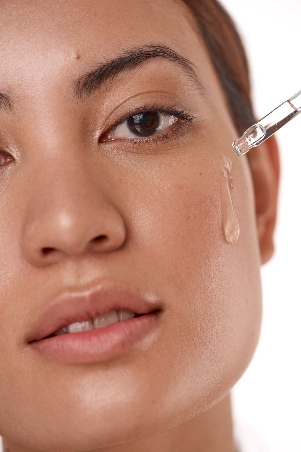 female face with a serum dropper