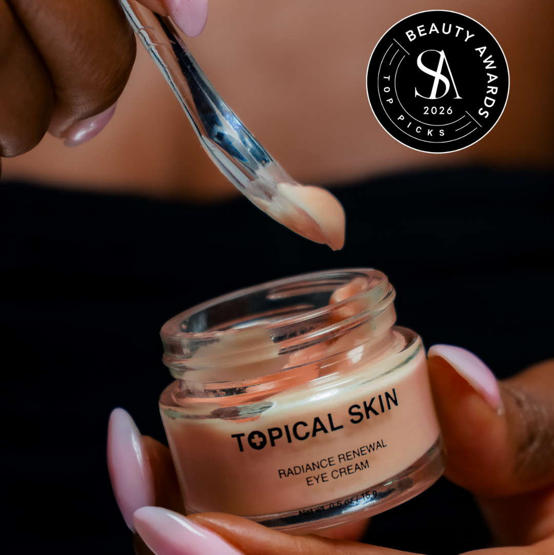A close-up of a hand holding an open glass jar of Topical Skin Radiance Renewal Eye Cream while another hand scoops the cream onto a spoon. The background is dark, and a 'Beauty Awards 2026' badge is visible in the top right corner.