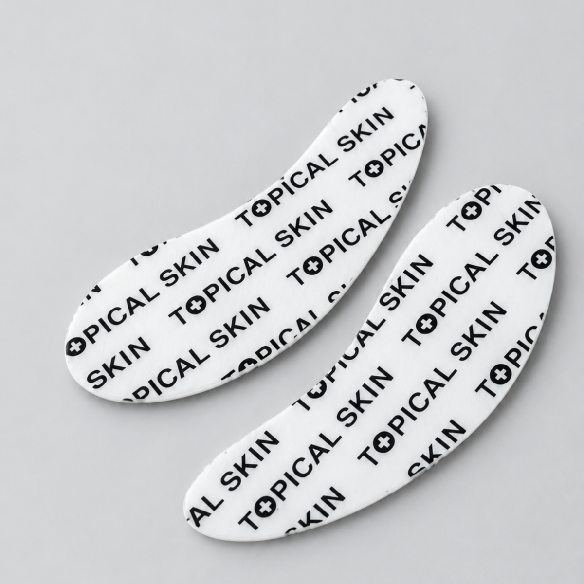 Two eye and smile white silicone patch sheets with the brand name 'TOPICAL SKIN' in black.