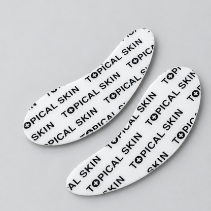 Two eye and smile white silicone patch sheets with the brand name 'TOPICAL SKIN' in black.