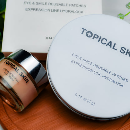 Topical Skin Hyaluronic Eye & Smile Reusable Patches set, featuring a round white lid, a small glass jar of radiance Renewal Eye Cream by TOPICAL SKIN on a wooden tray with green plants in the background.